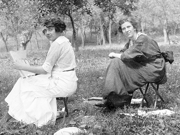 L’immagine ritrae due donne che leggono in un giardino; lo scatto è del 1917, il fotografo è sconosciuto.
