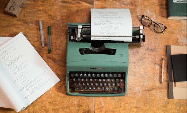 tavolo con macchina da scrivere, copione e occhiali